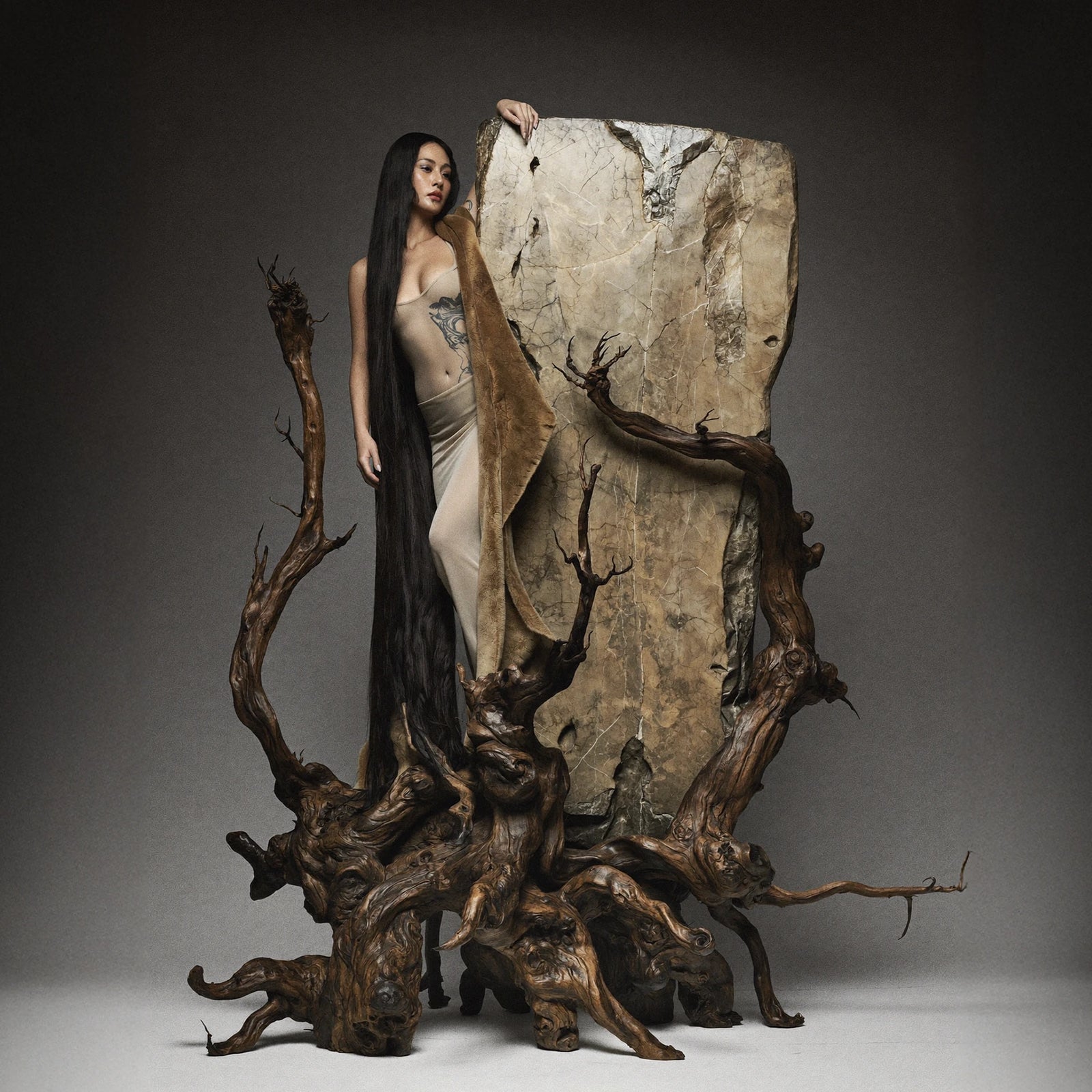 Editorial model with driftwood and stone sculpture